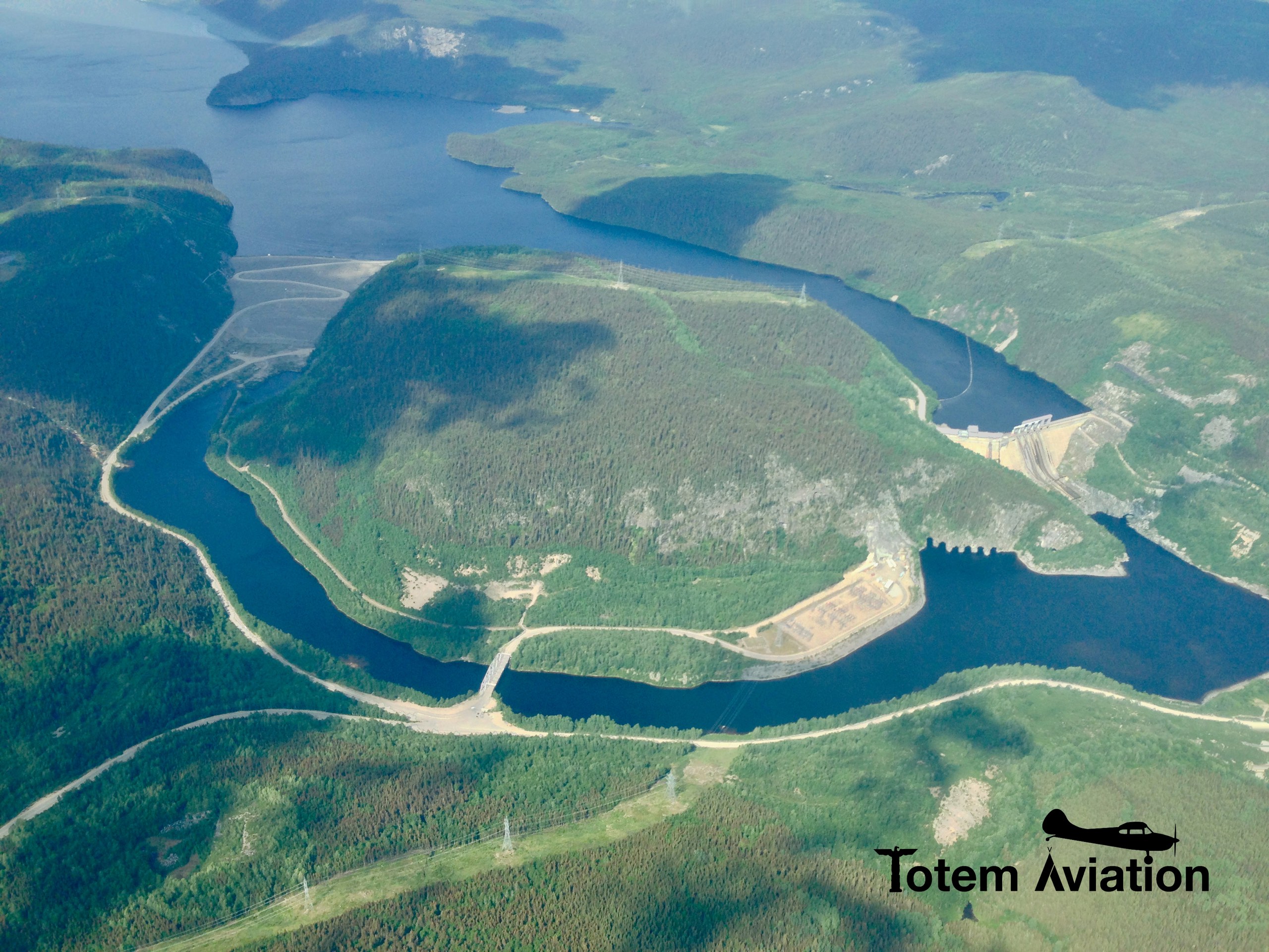 Complexe hydroélectrique de la Côte-Nord vu d'avion : réservoir, barrage, évacuateur de crues et rivière harnachée
